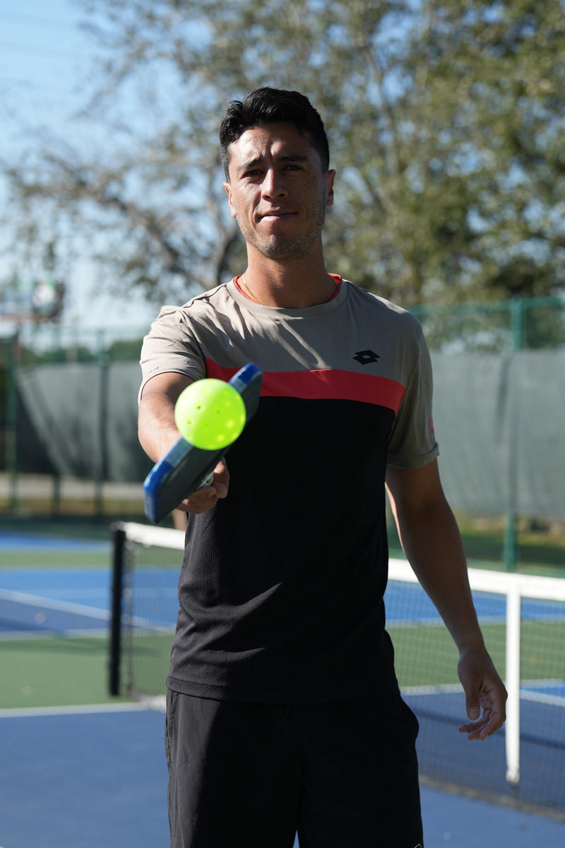 Pro pickleball player Pablo Tellez demonstrating Pickle Putty, showing effortless ball pickup with a paddle on the court.