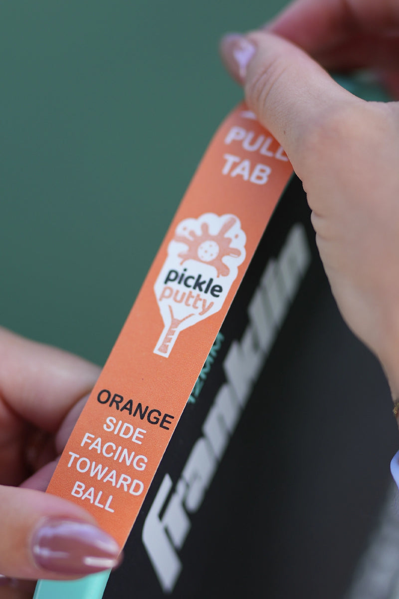 Pro pickleball player Parris Todd attaching Pickle Putty to her paddle, demonstrating easy setup for effortless ball pickup.